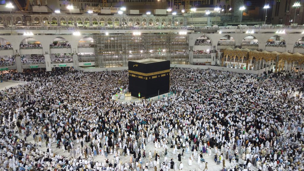 Aerial view of thousands of pilgrims gathered around the Kaaba at night in Mecca, Saudi Arabia.