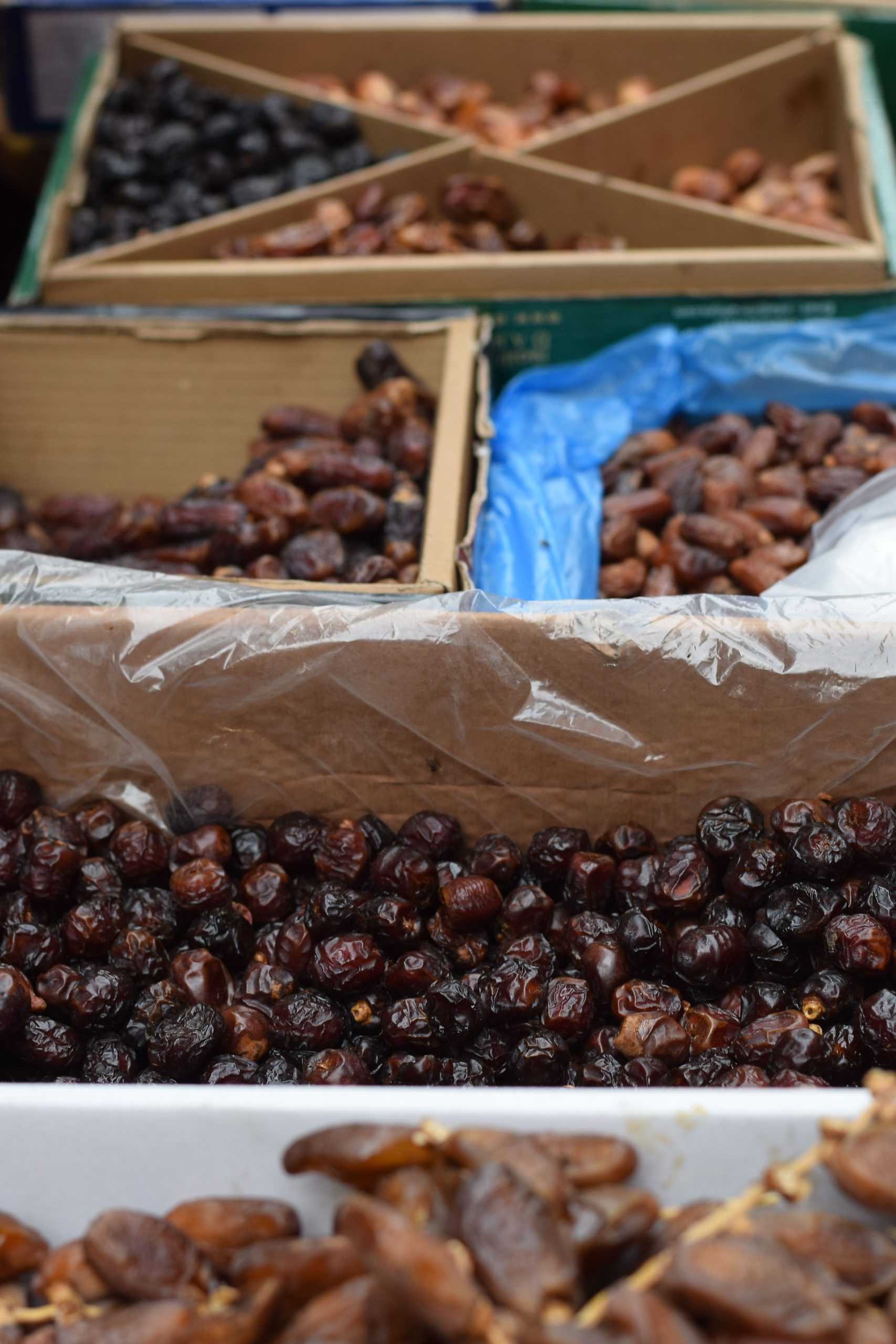 Close-up view of different types of dates displayed in boxes at a market in Dhaka, Bangladesh.