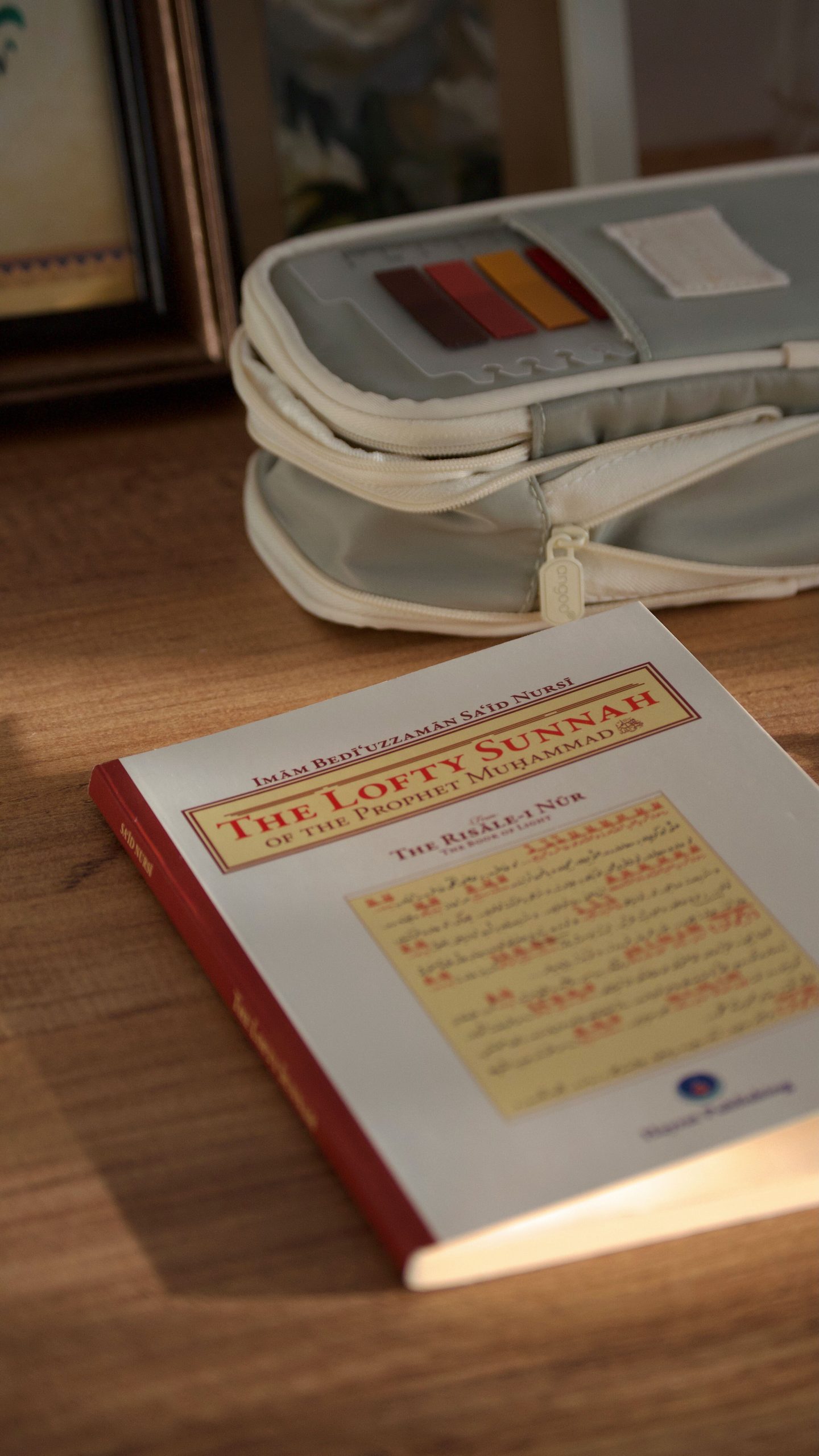 A religious book titled 'The Lofty Sunnah' resting on a sunlit wooden table.